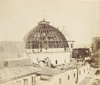 Photo showing scaffolding for the dome with nearby structures in the foreground.