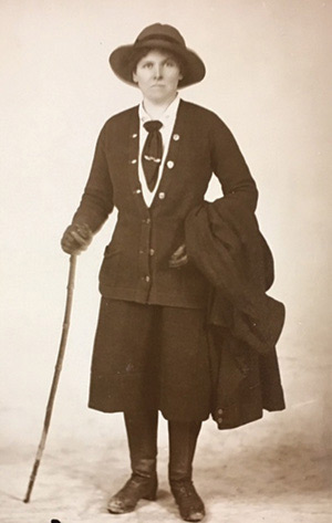 Early 20th century woman with walking stick, boots, big hat