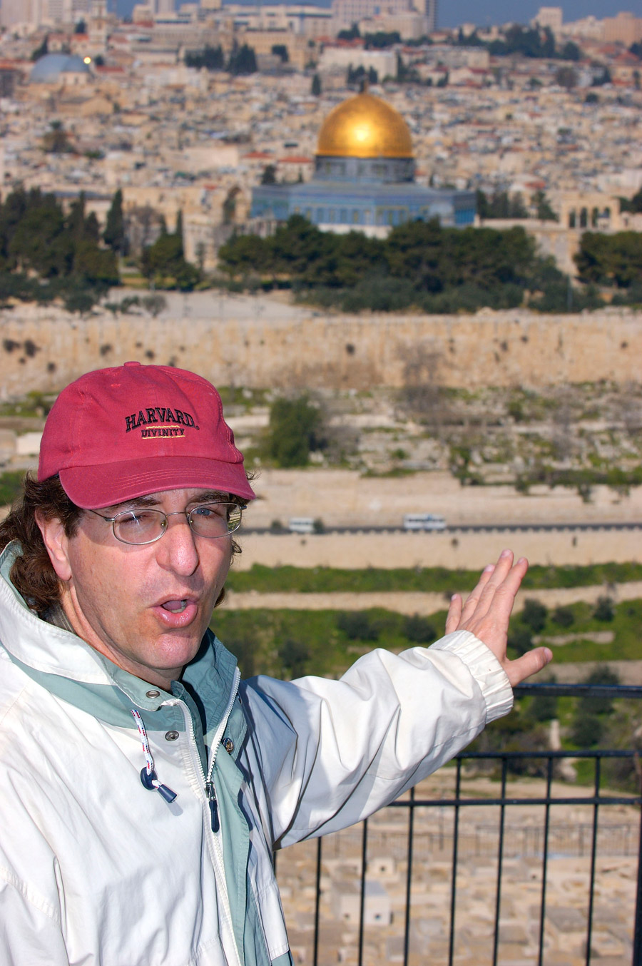 Photograph of tour guide gesturing toward Jerusalem's historic district in the background