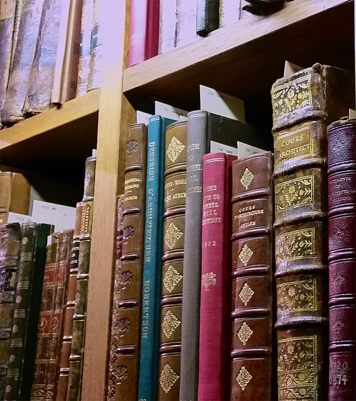 Shelf in the Perkins Library showing volumes of Cours Architect