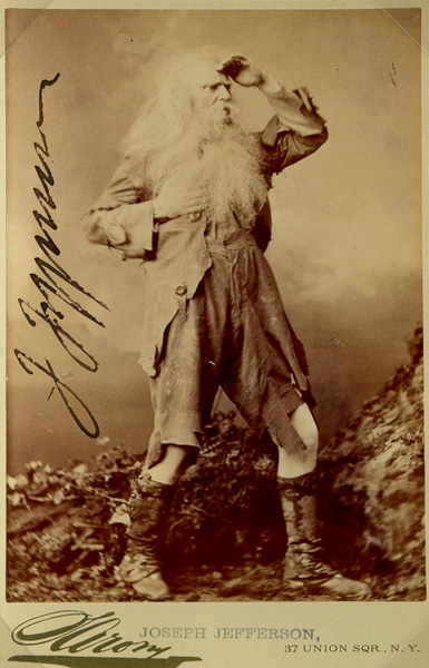 sepia tone photo of Joseph Jefferson in costume as Rip Van Winkle looking disheveled with a huge period, photo is signed 
