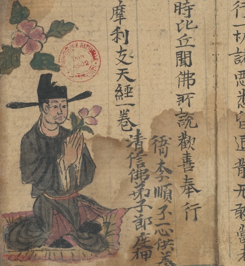 Man kneeling and holding a flower and facing printed text in Chinese characters.