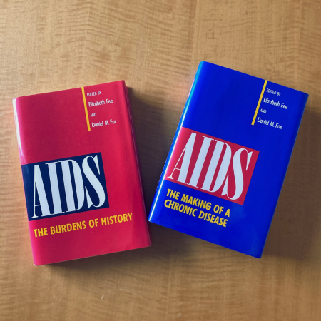 Two books sitting side-by-side on a table with bright red and blue covers
