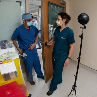 Two medical personnel standing next to virtual reality camera