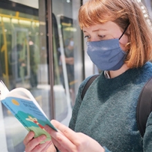 Woman in mask reading