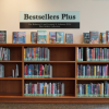 A bookshelf sits against a wall with a sign above it reading "Bestsellers Plus"