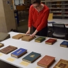 Two people review a display of rare books on a table